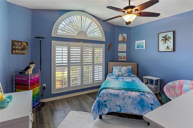 bedroom featuring ceiling fan, dark hardwood / wood-style floors, and a textured ceiling