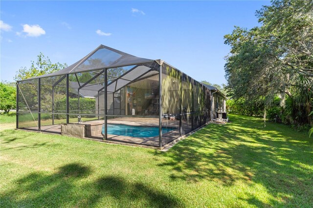 view of swimming pool with a lanai and a lawn