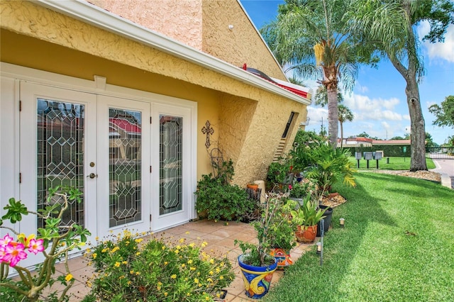 exterior space featuring french doors, a lawn, and a patio area