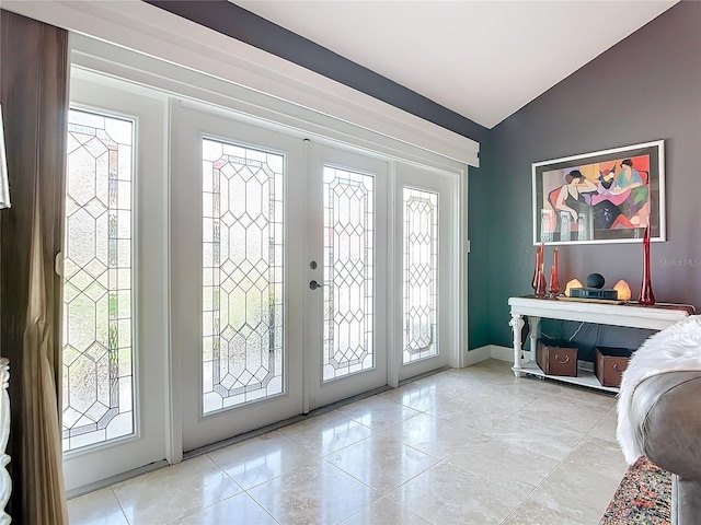 tiled entrance foyer featuring french doors and vaulted ceiling
