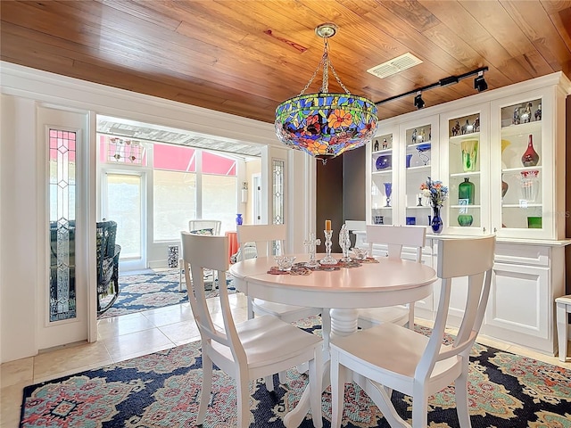 dining space with rail lighting, light tile patterned flooring, and wood ceiling