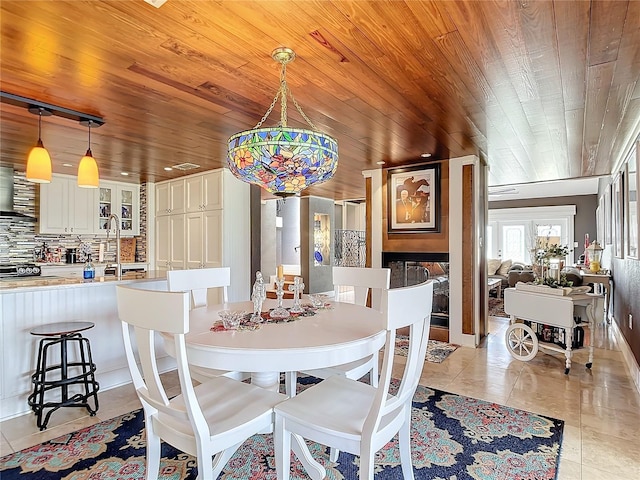 tiled dining area featuring sink and wood ceiling