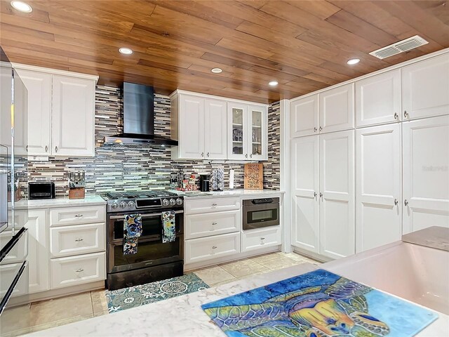 kitchen with double oven range, light tile patterned flooring, wall chimney exhaust hood, wooden ceiling, and white cabinets