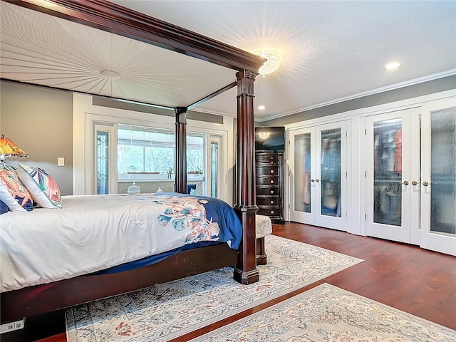bedroom featuring french doors, access to exterior, a textured ceiling, crown molding, and dark hardwood / wood-style floors