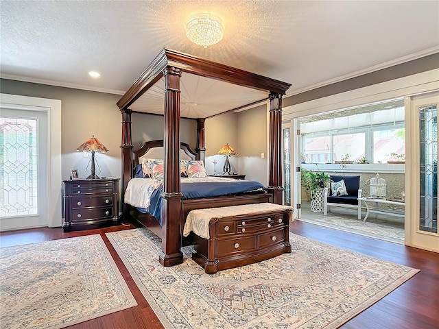 bedroom with a textured ceiling, access to exterior, crown molding, and wood-type flooring