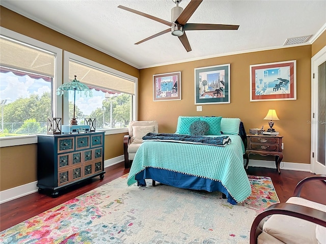 bedroom with crown molding, dark hardwood / wood-style flooring, a textured ceiling, and ceiling fan