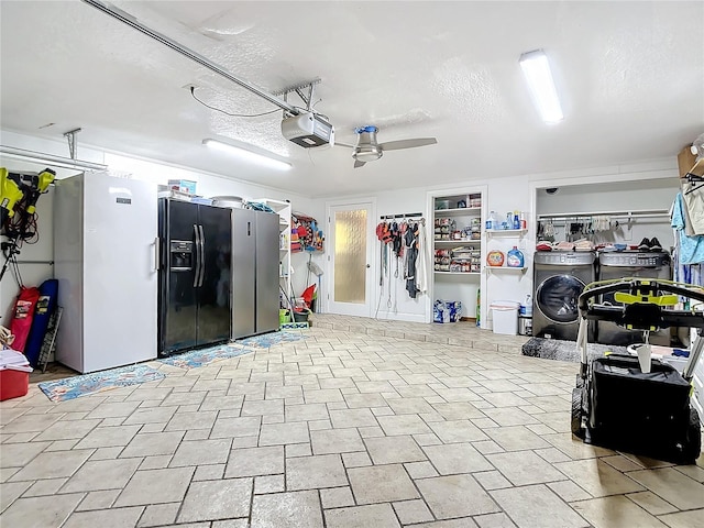 garage featuring a garage door opener, washer / clothes dryer, white fridge, and black fridge