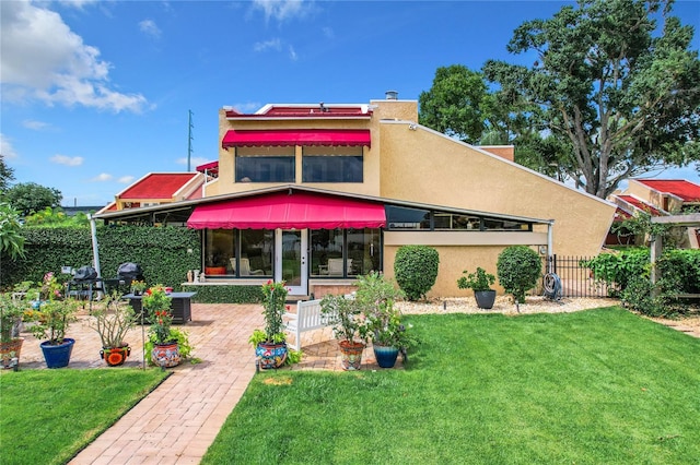 rear view of house with a yard and a patio area