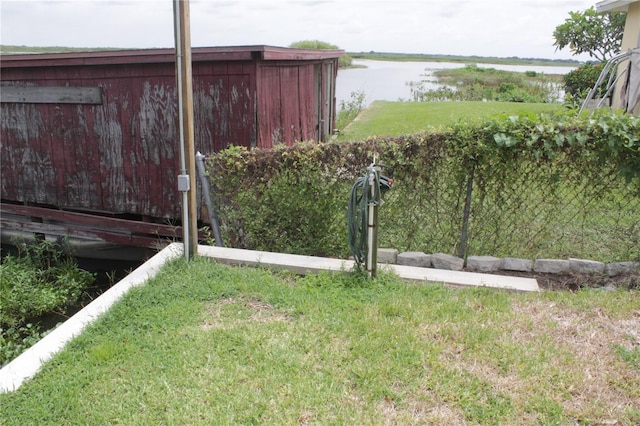 view of yard with a water view and an outbuilding