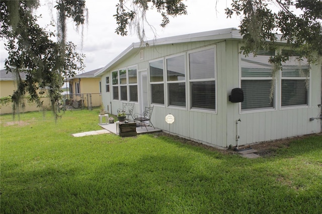 back of property featuring a lawn