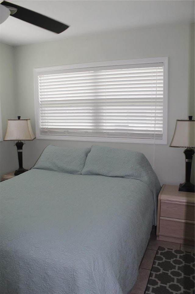 tiled bedroom featuring ceiling fan