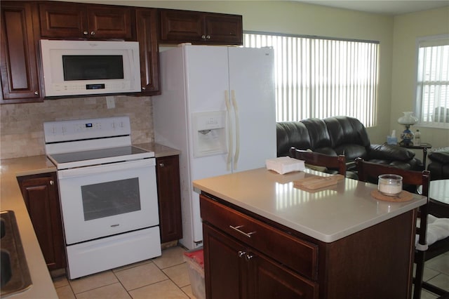 kitchen with light tile patterned floors, white appliances, and decorative backsplash