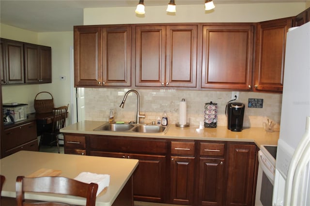 kitchen featuring sink, white appliances, and decorative backsplash