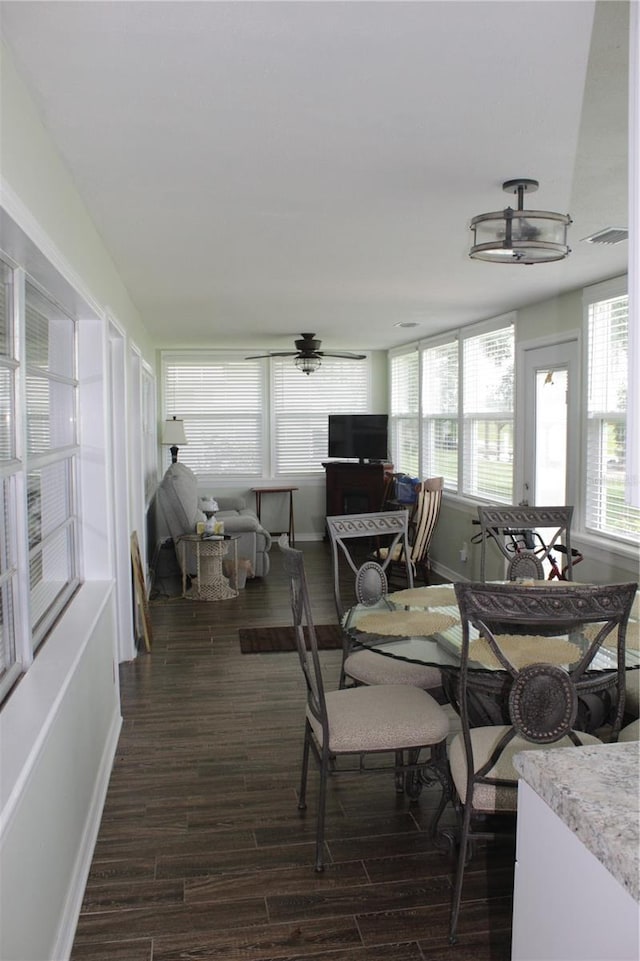 dining room with ceiling fan and dark wood-type flooring