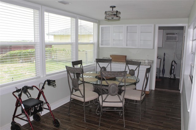 dining room with dark hardwood / wood-style floors and an AC wall unit