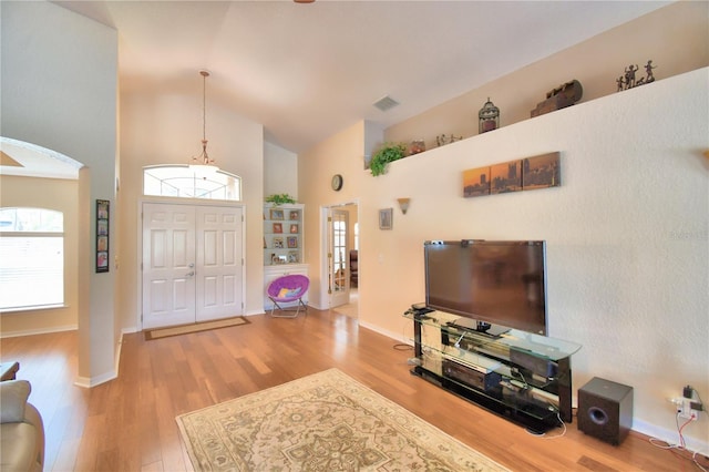 entrance foyer with high vaulted ceiling and light wood-type flooring