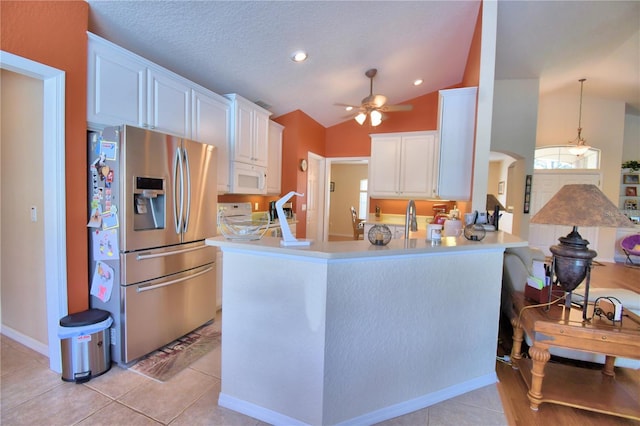 kitchen featuring ceiling fan, white cabinetry, kitchen peninsula, and stainless steel fridge