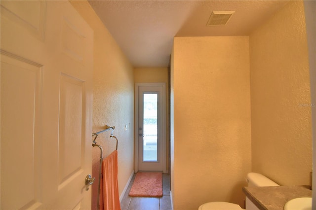 bathroom featuring a textured ceiling, tile patterned floors, vanity, and toilet