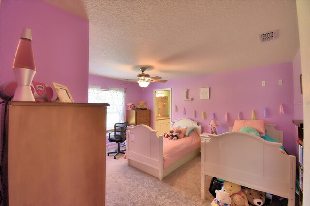 bedroom with connected bathroom, ceiling fan, a textured ceiling, and light carpet