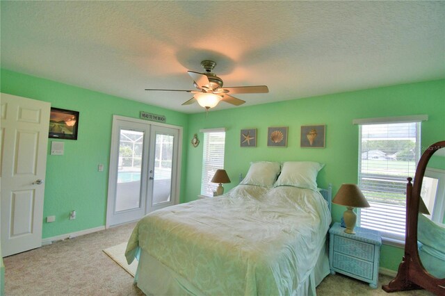 bedroom featuring ceiling fan, a textured ceiling, light colored carpet, and access to exterior