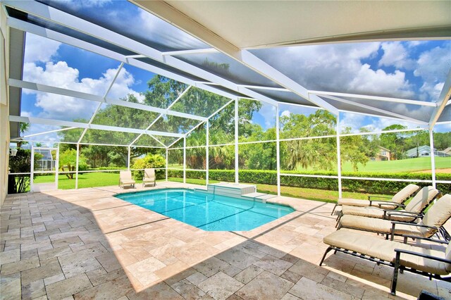 view of swimming pool featuring glass enclosure and a patio