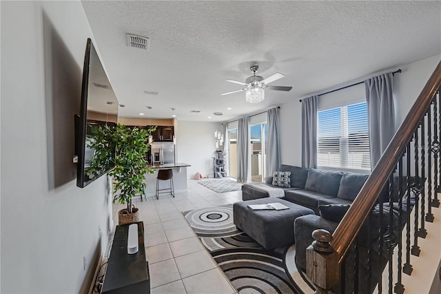 tiled living room featuring a textured ceiling and ceiling fan