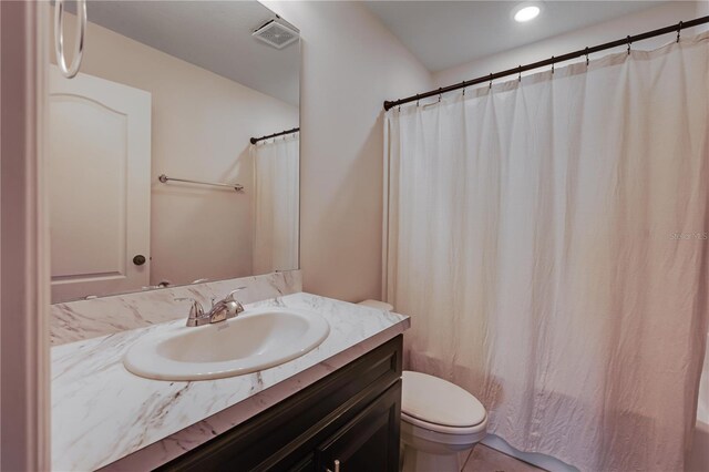 bathroom featuring vanity, tile patterned floors, and toilet