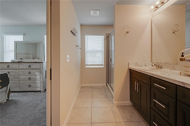 bathroom featuring vanity, a wealth of natural light, tile patterned flooring, and walk in shower