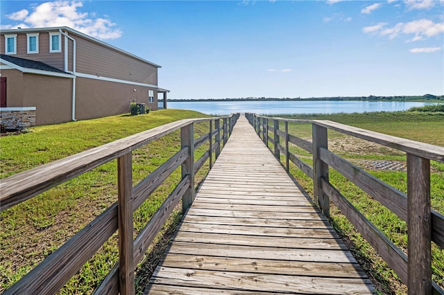 dock area with a water view and a yard