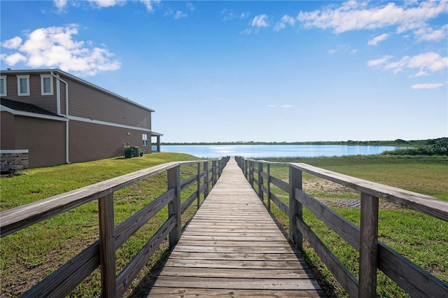 dock area with a water view and a yard