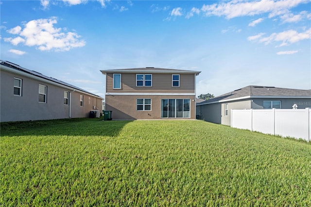 back of house featuring central AC and a lawn