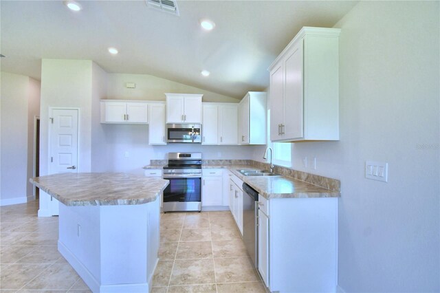 kitchen with light tile patterned floors, white cabinets, a kitchen island, appliances with stainless steel finishes, and sink