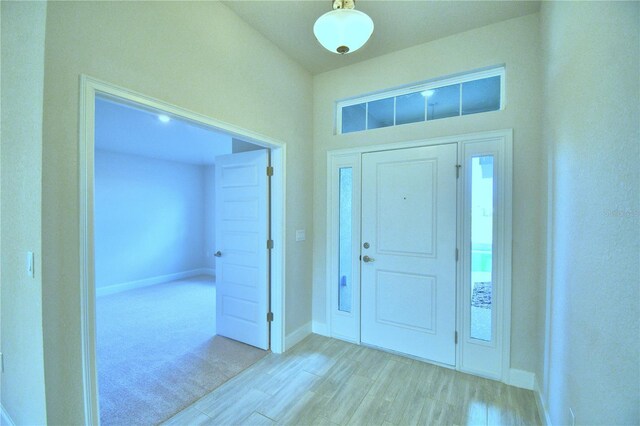 foyer featuring light carpet