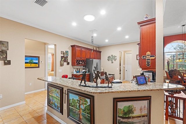 kitchen with light tile patterned floors, crown molding, stainless steel fridge, light stone counters, and kitchen peninsula