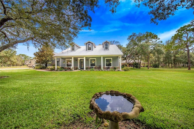 cape cod home with covered porch, metal roof, and a front lawn