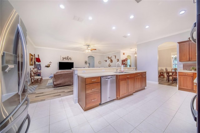 kitchen featuring appliances with stainless steel finishes, sink, light hardwood / wood-style floors, crown molding, and ceiling fan