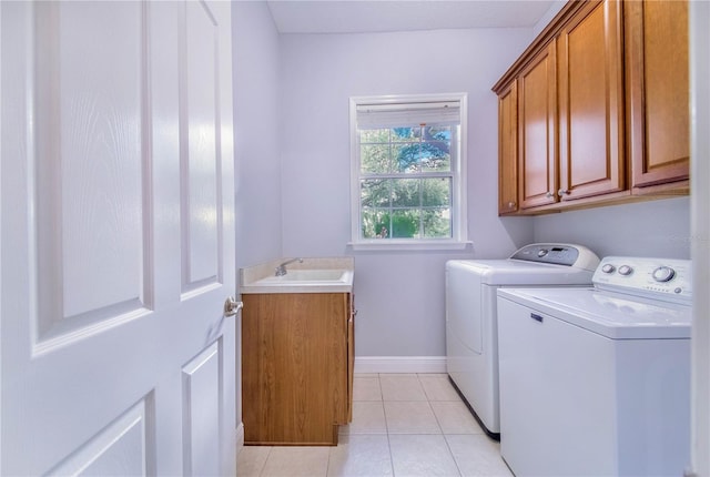 laundry area featuring light tile patterned flooring, independent washer and dryer, sink, and cabinets