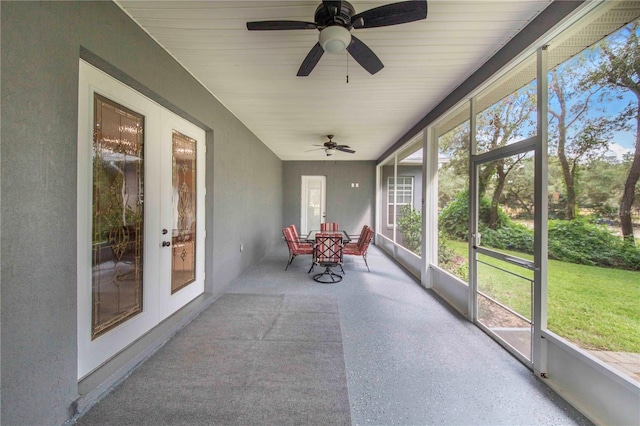 unfurnished sunroom featuring ceiling fan and french doors