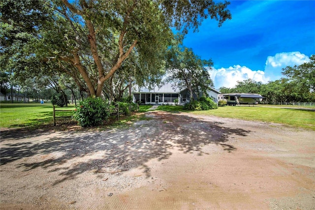 view of front of property featuring a front yard and a sunroom