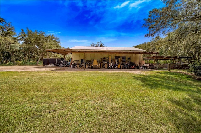 back of property featuring a lawn and an outdoor structure