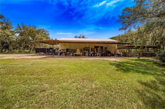 back of house with metal roof, a carport, and a lawn