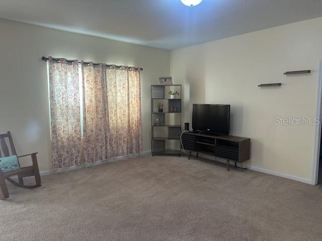 carpeted living room featuring baseboards