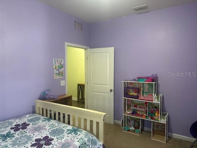 carpeted bedroom featuring visible vents and baseboards