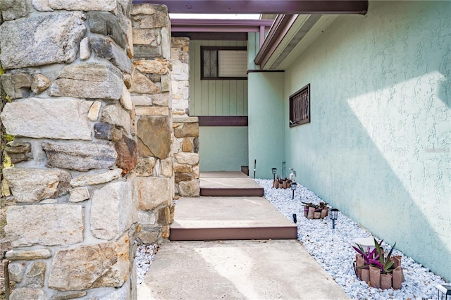 property entrance with stone siding and stucco siding