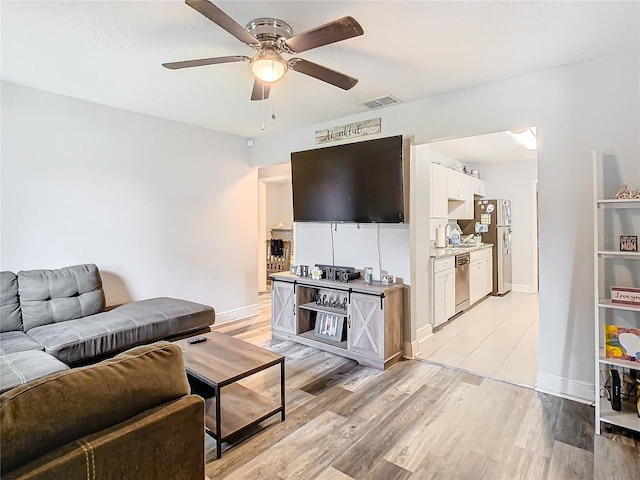 living room with light hardwood / wood-style flooring and ceiling fan