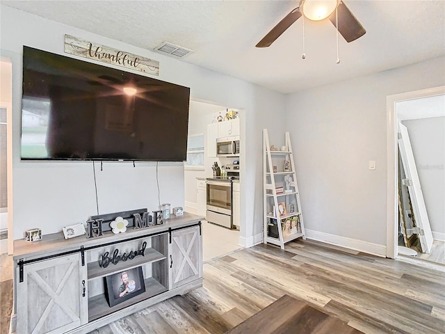 living room with ceiling fan and light wood-type flooring