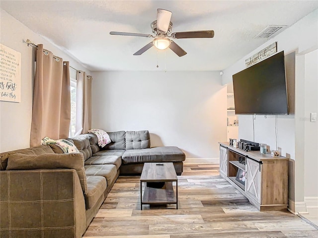 living room with ceiling fan and light hardwood / wood-style flooring