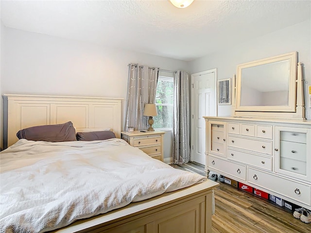 bedroom featuring a textured ceiling and light wood-type flooring