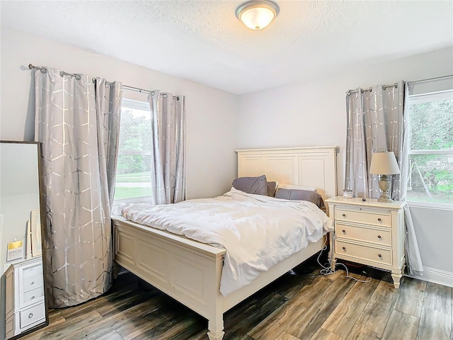 bedroom featuring dark wood-type flooring and a textured ceiling