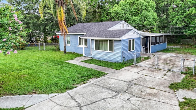 view of front of property featuring a front yard and a sunroom